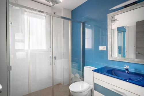 a blue bathroom with a toilet and a sink at Casa Pablo -Granada- in Granada