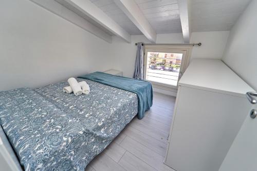 um pequeno quarto com uma cama e uma janela em Affittimoderni Isola Rossa Borgo - IRGI11 em Isola Rossa