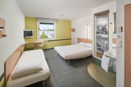 a hospital room with two beds and a tv at ibis budget Wrocław Południe in Wrocław