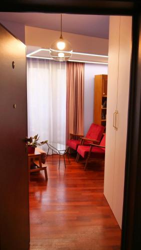 a living room with a red couch and a table at Downtown Italian Studio in Bucharest