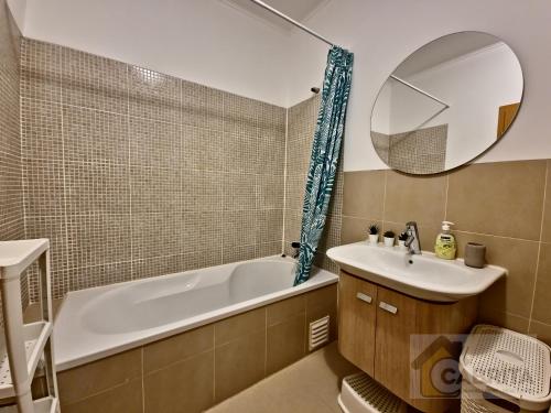 y baño con bañera, lavabo y espejo. en Casa dos Peixinhos T1 by YHA, en Conceição