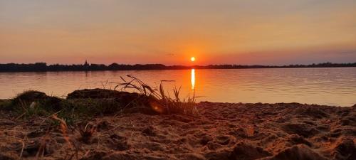 a sunset on the shore of a body of water at Domek Triftberg in Chojna