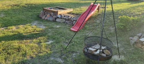 a playground with a red slide and a fire pit at Domek Triftberg in Chojna