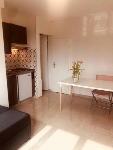 a living room with a table and a kitchen at Sweet, light, simple studio- free parking nearby in Lausanne