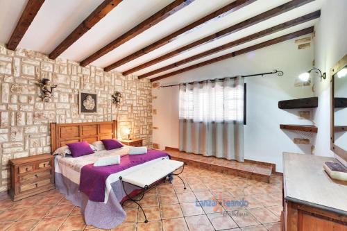ein Schlafzimmer mit einem Bett und einer Steinmauer in der Unterkunft Vivienda Vacacional Finca Aradri in Tinguatón