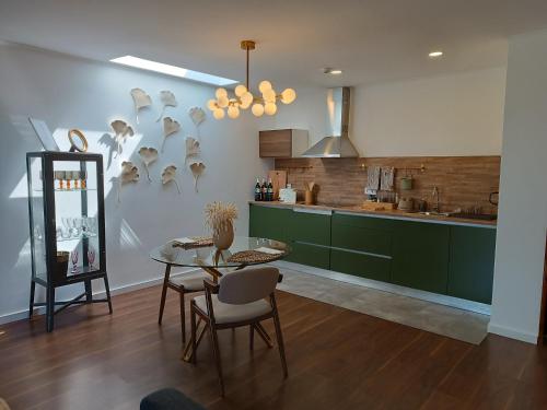 a kitchen with green cabinets and a table and chairs at Casa do Romezal in Peso da Régua