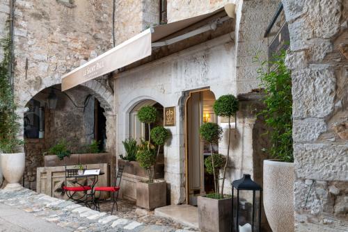a restaurant in a stone building with a table and chairs at Hotel Le Saint Paul in Saint-Paul-de-Vence