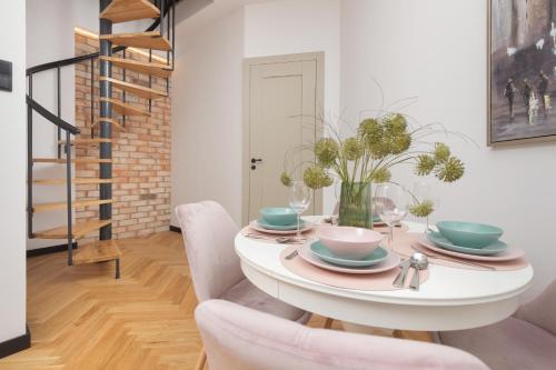 a dining room with a white table and chairs at Praga Duplex Apartment Premium Warsaw by Renters in Warsaw