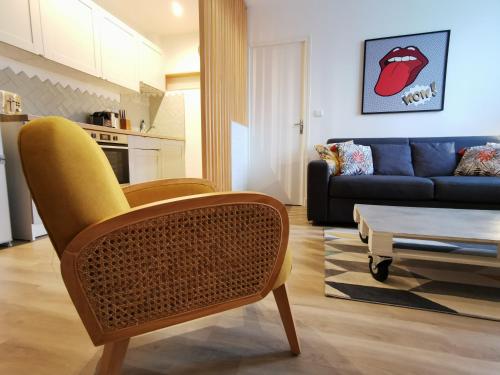 sala de estar con silla amarilla y sofá en Happy Kool - centre ville + wifi + parking privé, en Blois