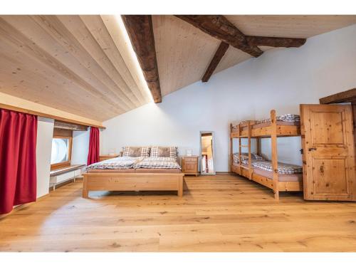 een slaapkamer met 2 stapelbedden en rode gordijnen bij Wohnung von Schorsch in Splügen