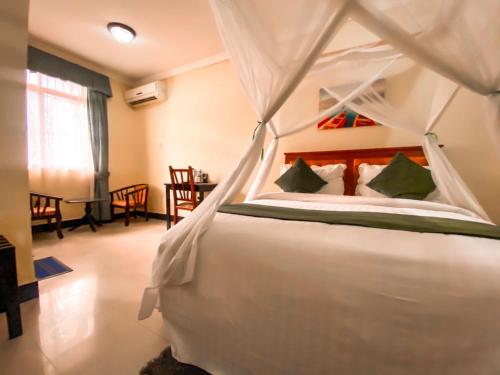 a bedroom with a white bed with a canopy at M Hotel in Dar es Salaam