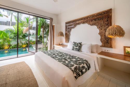 a bedroom with a large bed and a large window at Yogi Surf Villas Complex Canggu in Canggu