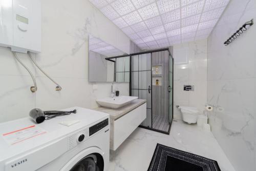 a white bathroom with a sink and a toilet at Villa with Pool and Backyard in Kepez 