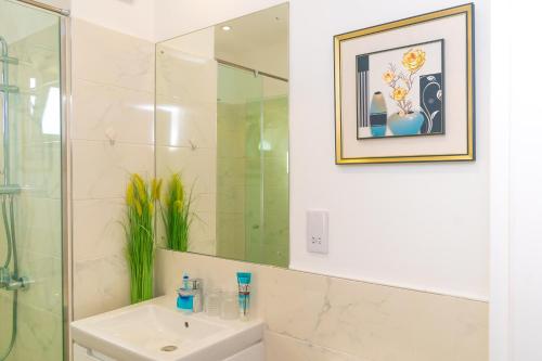 a bathroom with a sink and a mirror at Piano and Gold at The Lennox, Airport Residential in Accra