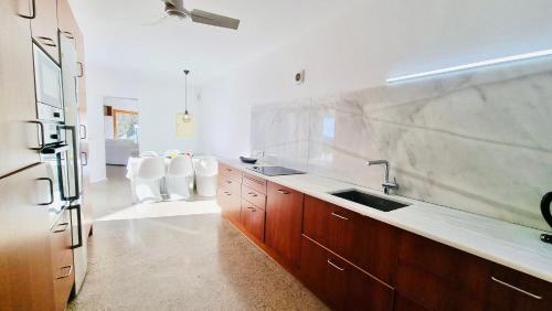 a large kitchen with a sink and two white chairs at Villa Boutique ibiza in Santa Eularia des Riu