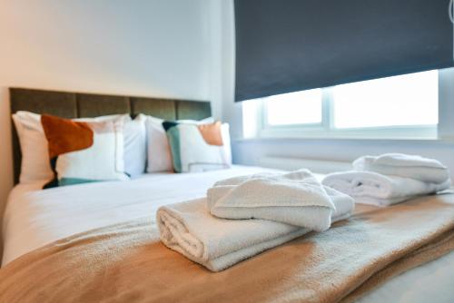- un lit avec des serviettes assises au-dessus dans l'établissement Hillside House, à Nottingham