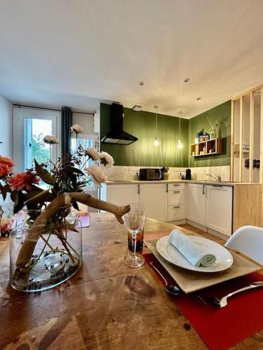 une cuisine avec une table avec un vase de fleurs dessus dans l'établissement Chez Frida, Escapade nîmoise, à Nîmes