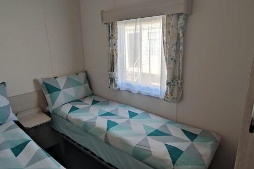 Habitación pequeña con cama y ventana en 113 Seawick, 2 Bedrooms Free WiFi, en Jaywick Sands