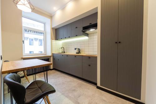 a kitchen with gray cabinets and a table and a window at Idea Design Apart-Hotel Prorizna in Kyiv