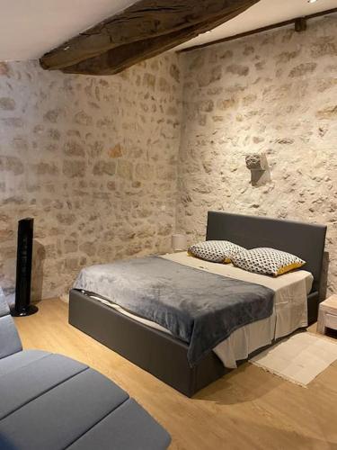 a bedroom with a bed and a stone wall at Loft en plein cœur du village in Saint-Paul-de-Vence
