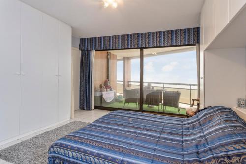 a bedroom with a bed and a large window at seaview apartment margo in Blankenberge