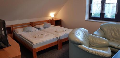 Cette chambre comprend un lit, un canapé et une chaise. dans l'établissement Vila Jedľa, à Vysoké Tatry