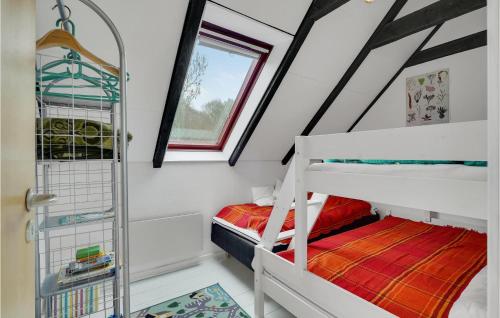 - une chambre mansardée avec 2 lits superposés et une fenêtre dans l'établissement Stunning Apartment In Tranekr With Wifi, à Tranekær