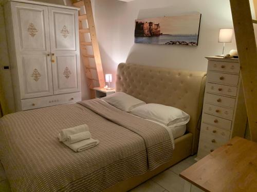 um pequeno quarto com uma cama e uma cómoda em La Casa Di Hoby em Nápoles