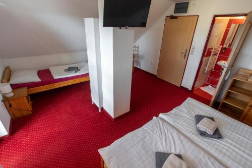 a room with two beds and a flat screen tv at Wellness & Restaurant U Fandy in Lhotka
