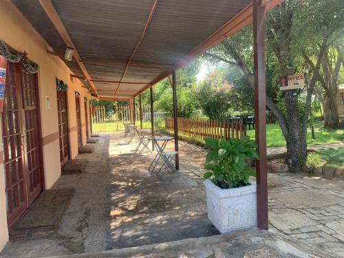 a porch of a building with a wooden roof at Eden Guest Farm in Bloemfontein