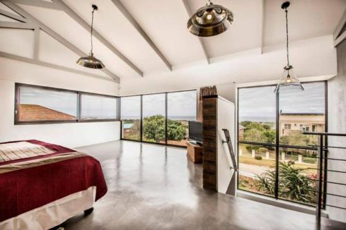 a large bedroom with a bed and large windows at Bromley loft in Port Alfred