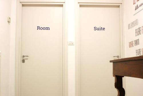 two doors with the words room and suite on them at Via del Corso Room&Suite in Matera