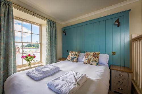 a bedroom with a large bed with a window at Edgcumbe Arms in Torpoint