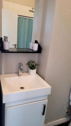 a white bathroom with a sink and a mirror at Gorgeous in Johannesburg