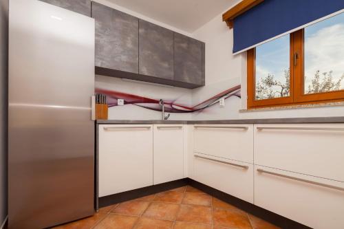 a kitchen with white cabinets and a window at Villa Mirjana in Banjole