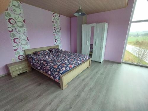 um quarto com uma cama num quarto com paredes roxas em La course du soleil em Saint-Hubert