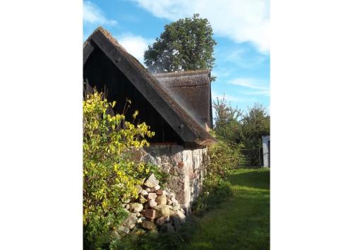 an old stone wall with a pile of rocks next to it at Reetgedecktes Ferienhaus Ulrichshorst in Ulrichshorst