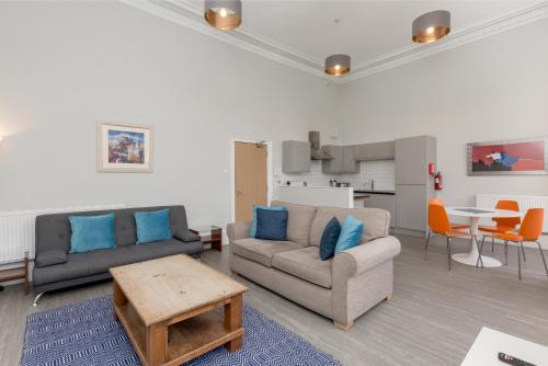 a living room with two couches and a table at Southside Apartments by Destination Edinburgh in Edinburgh