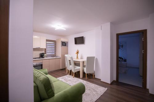 a living room with a green couch and a table at Apartament Gold in Târgu Ocna