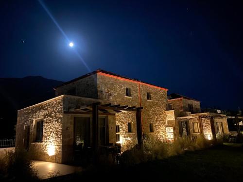 a stone house at night with the moon overhead at VILLAS BALATSOURAS in Paleros