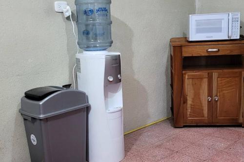 a water cooler sitting next to a trash can at Casa para viajes de descanso o de negocios in Quetzaltenango