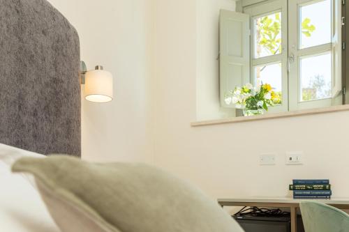 a bedroom with a mirror and a table with a window at Monte Forru in Baunei