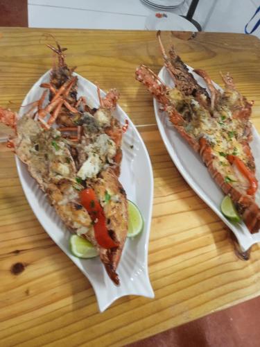 two plates of food on a table with shrimp at Arena Oceanview Hotel & La Terraza Restaurant in Las Galeras