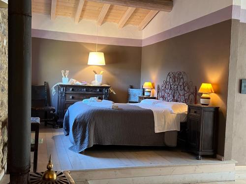 a bedroom with a bed and a dresser and lamps at Borgo di Quarazzana holiday house for large groups Tuscany in Agnino