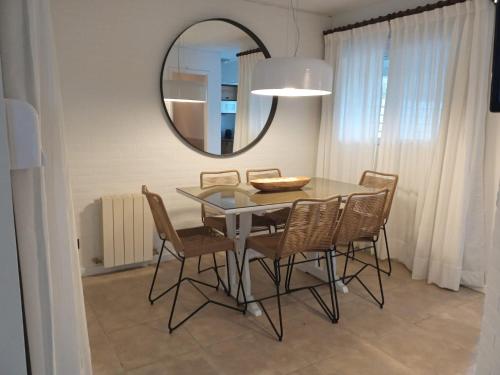 a dining room with a table and chairs and a mirror at Carilo Hills by bund in Carilo