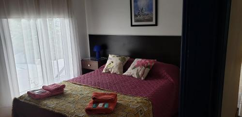 Un dormitorio con una cama con dos bolsas. en Encantada Apart en Ushuaia