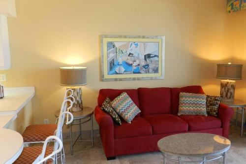 a living room with a red couch and a table at 6th Floor 1 BR Direct Oceanfront Condo Wyndham Ocean Walk - Daytona Funland 606 in Daytona Beach
