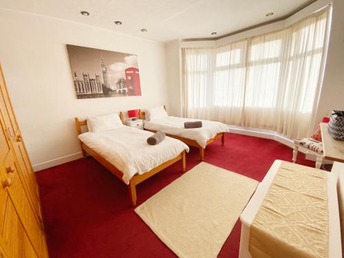 um quarto com 2 camas e um tapete vermelho em Cosy Old House Free Parking Close To Town & Beach em Bournemouth