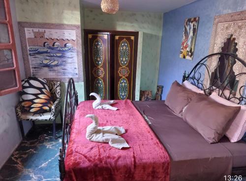dos cisnes sentados en una cama en un dormitorio en Hostel Marrakech Rouge, en Marrakech