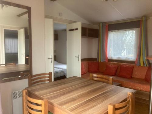 un salon avec une table et un canapé dans l'établissement Camping l’r pur, à Saint-Vincent-sur-Jard